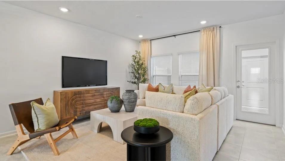 A living room features a sectional sofa, wooden media console, and a leather accent chair — 11309 RISING SUN STREET, ORLANDO, FL