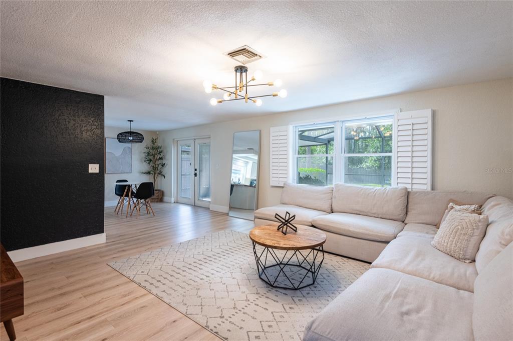 A living room features a sectional sofa, a round coffee table, and a dining area — 2712 CEDARIDGE DRIVE, TAMPA, FL