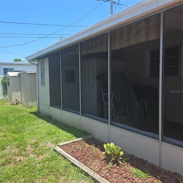 A screened-in porch is attached to the side of a mobile home with a shed — 27466 US HIGHWAY 19 N UNIT 24, CLEARWATER, FL