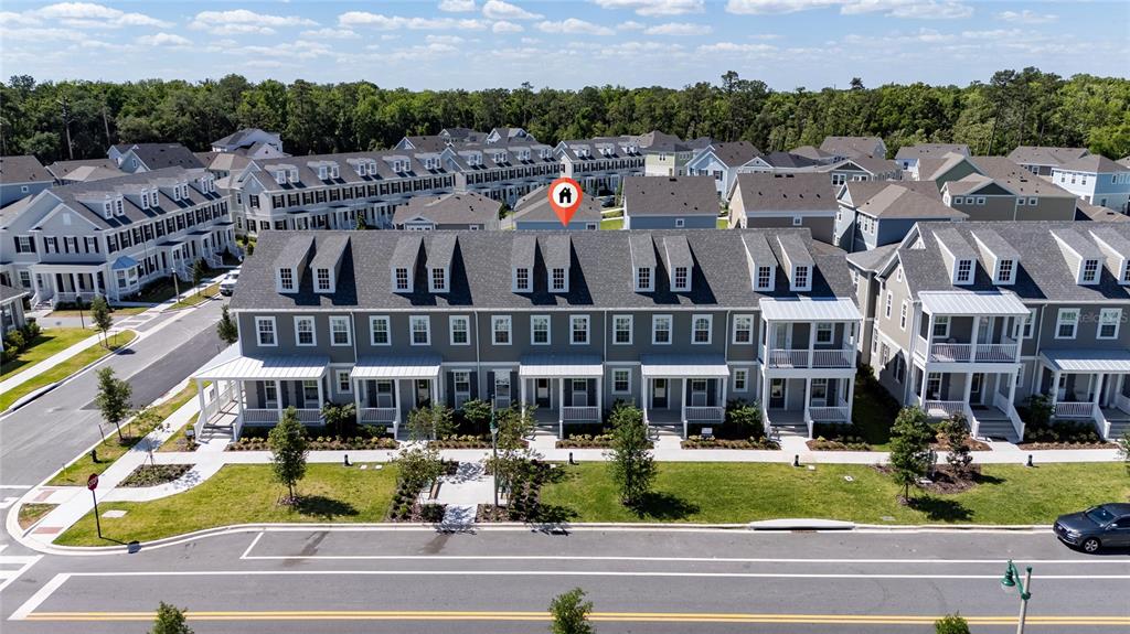 An aerial view shows a row of multi-story townhomes with grey siding and gabled roofs — 2414 CELEBRATION BOULEVARD, KISSIMMEE, FL