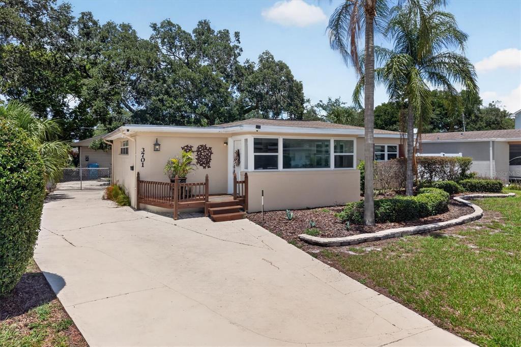 A single-story house with a beige exterior, a wooden front deck, and a concrete driveway — 3701 VIRGINIA DRIVE, ORLANDO, FL