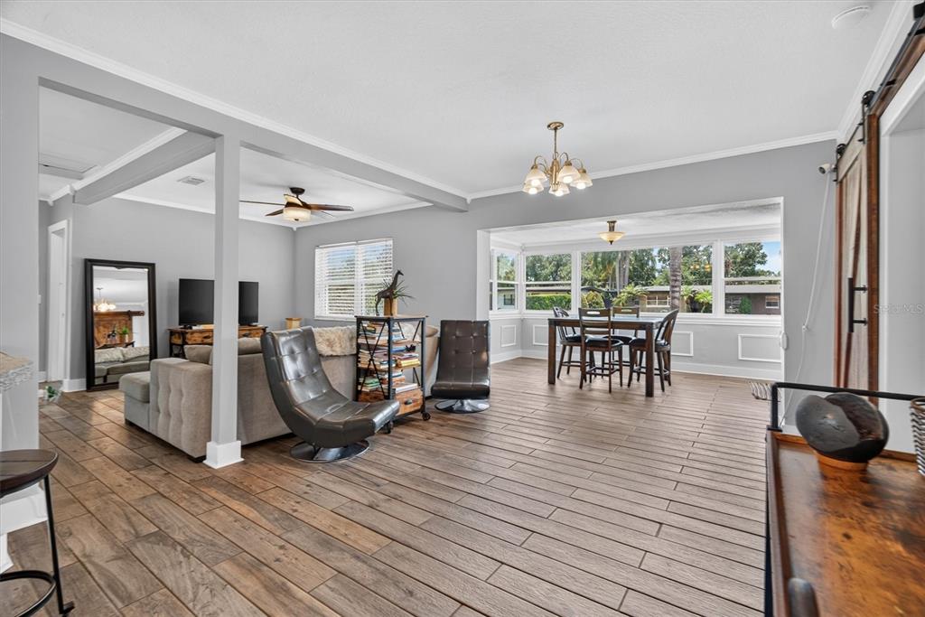 A living and dining area features gray walls, wood-look tile flooring, and large windows — 3701 VIRGINIA DRIVE, ORLANDO, FL