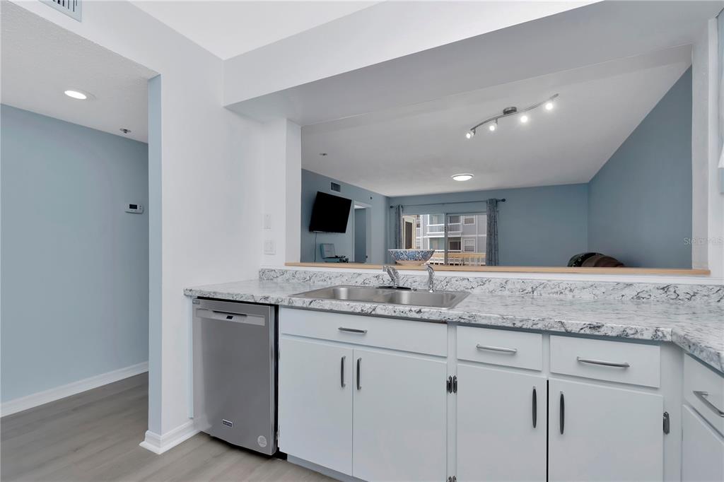 A kitchen with white cabinets, granite countertops, and a stainless steel dishwasher — 6817 STONES THROW CIRCLE N UNIT 17203, ST PETERSBURG, FL