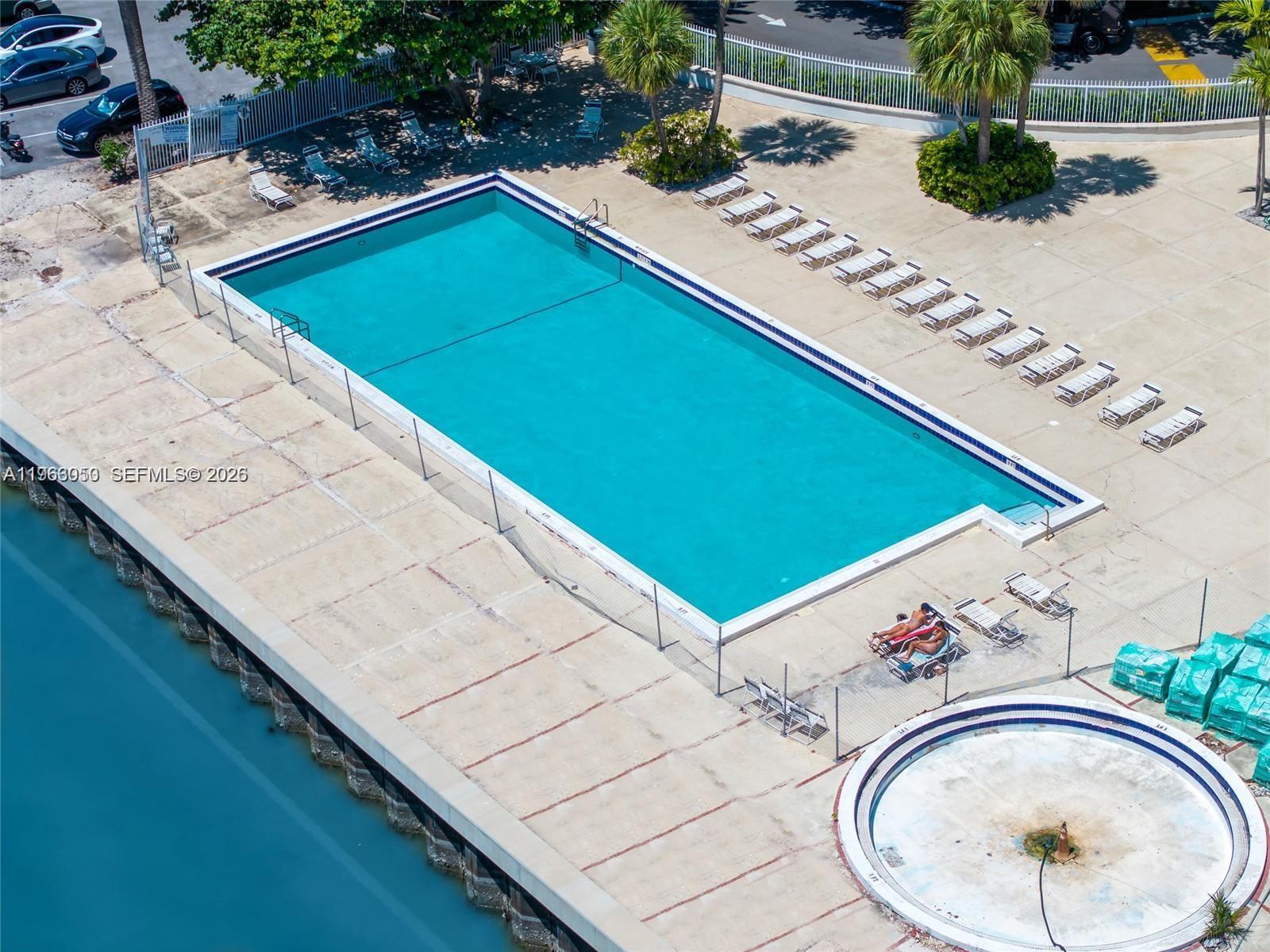 An aerial view shows a rectangular swimming pool, a circular fountain, and lounge chairs — 7441 Wayne Ave # 9I, Miami Beach FL 33141, MIAMI BEACH, FL