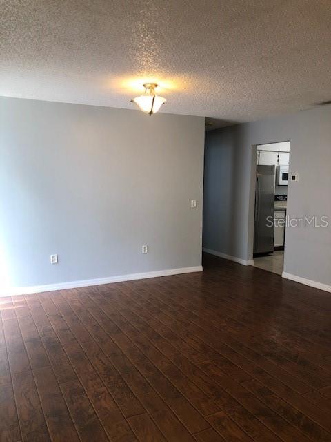A room with light gray walls, a ceiling light fixture, and dark wood-look flooring — 810 E 20TH STREET, SANFORD, FL