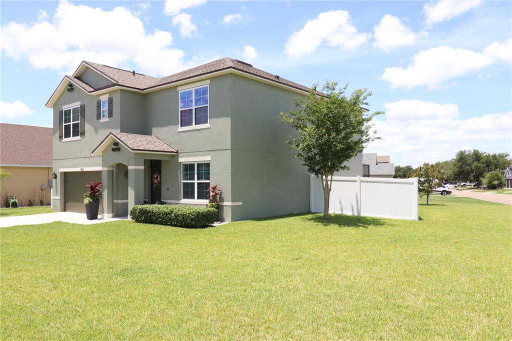 A two-story green house with a two-car garage and a concrete driveway — 863 LAKE CUMMINGS BOULEVARD, LAKE ALFRED, FL