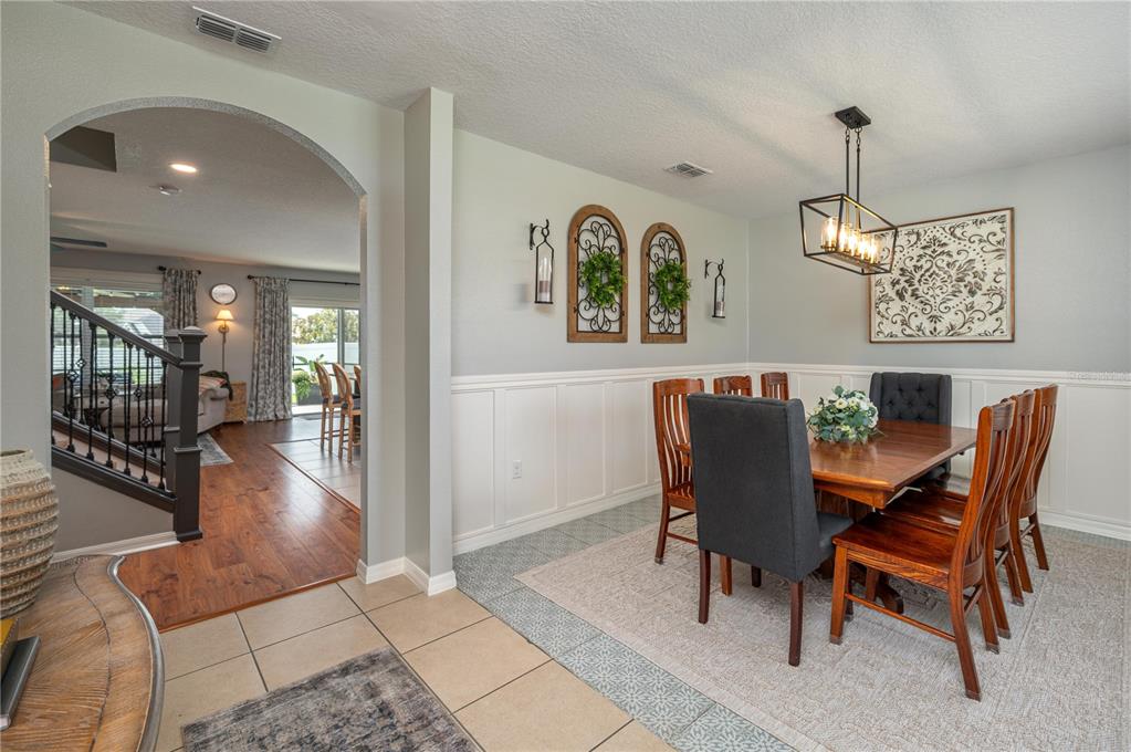 A two-story, green-stucco suburban house with a white vinyl fence and a grassy yard — 863 LAKE CUMMINGS BOULEVARD, LAKE ALFRED, FL