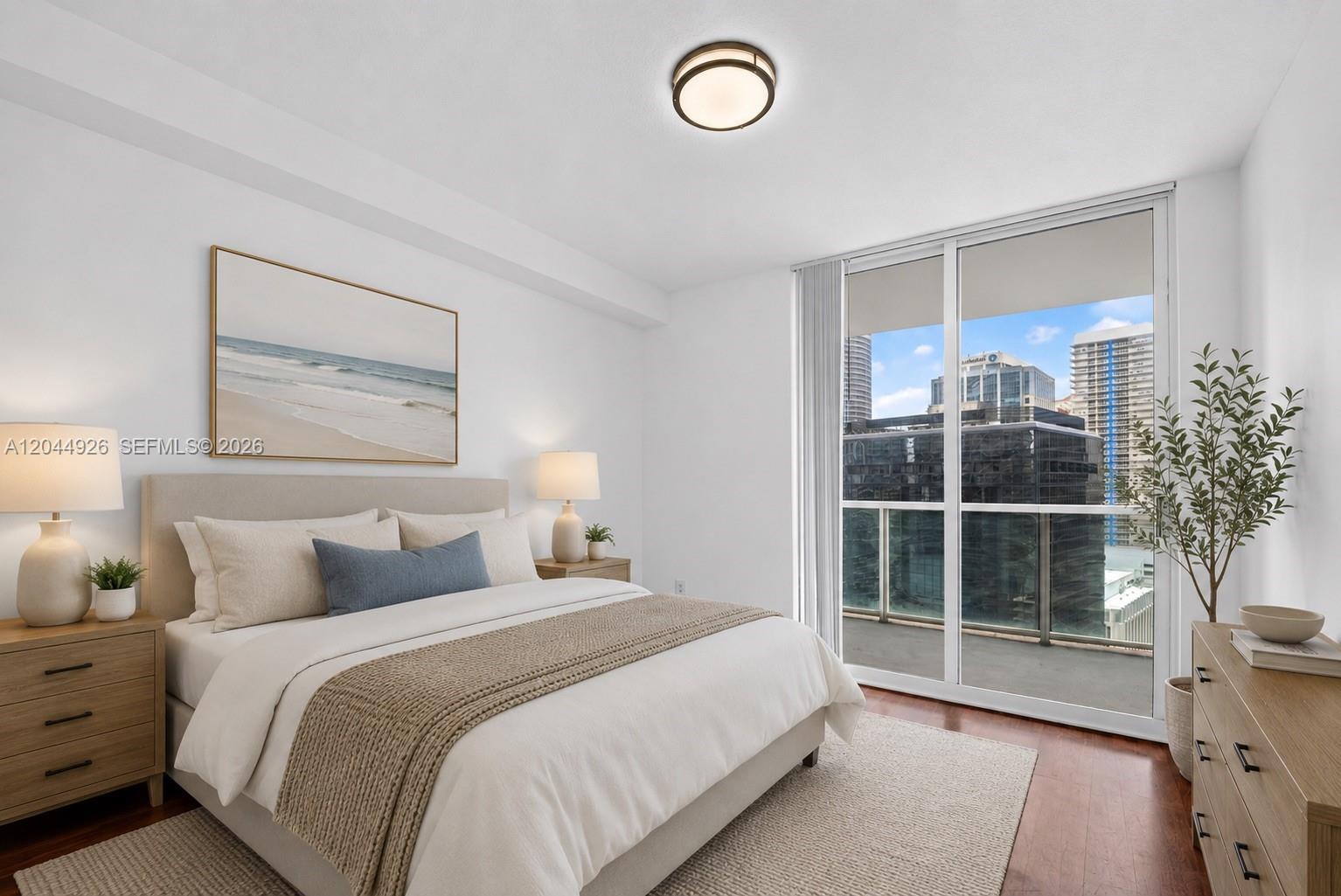 A bedroom with a queen bed, wooden furniture, and a balcony overlooking city buildings — 1250 S Miami Ave # 2004, Miami FL 33130, MIAMI, FL
