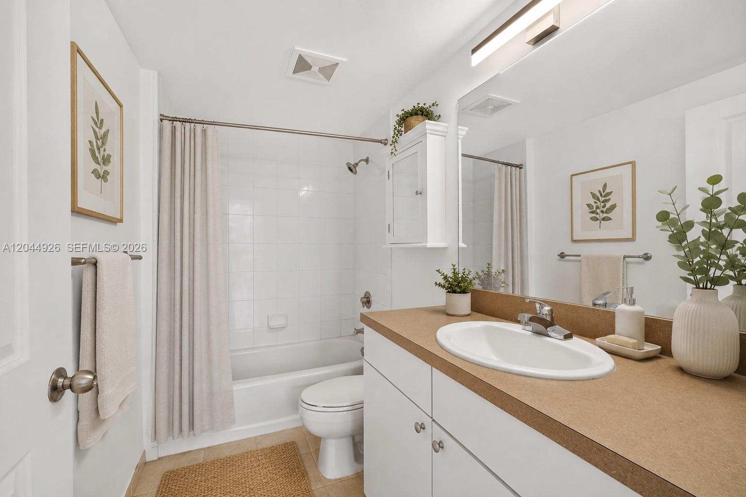 A bathroom features a white vanity with a tan countertop, a tub-shower combo, and neutral decor — 1250 S Miami Ave # 2004, Miami FL 33130, MIAMI, FL