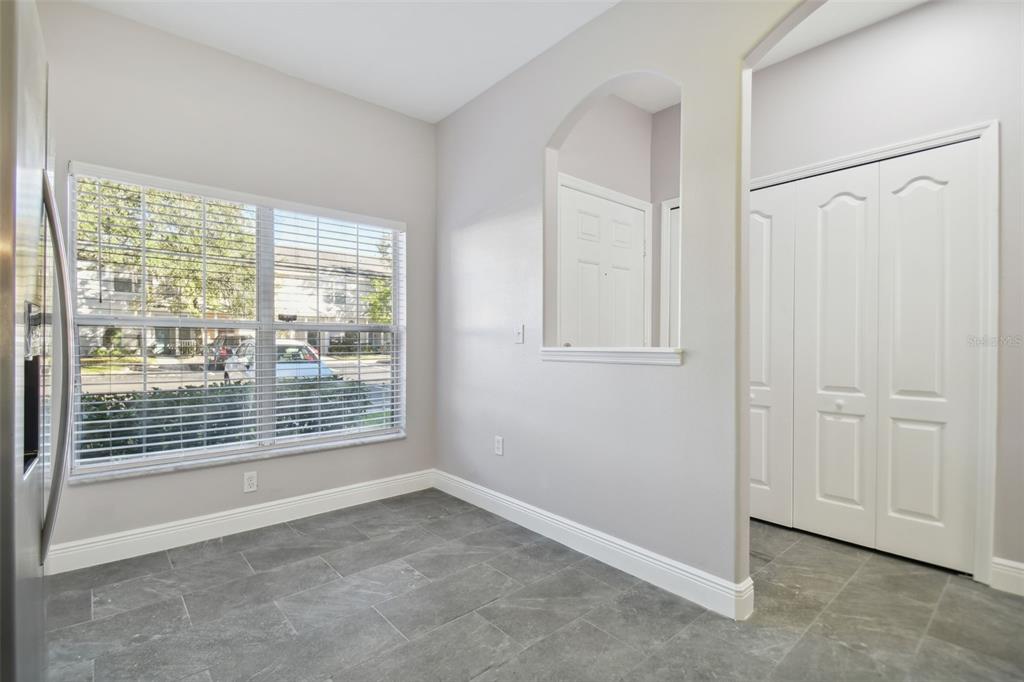 A room with gray tile flooring, a large window, and a white bi-fold closet door — 3430 HIGH HAMPTON CIRCLE, TAMPA, FL