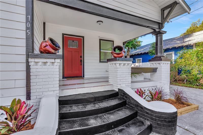 A front porch with black steps, white brick columns, and a red front door — 705 E PLYMOUTH STREET, TAMPA, FL