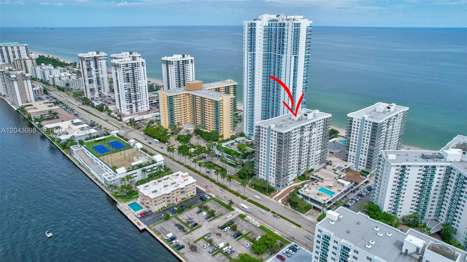An aerial view shows multiple high-rise residential buildings along a coastline with a red arrow — 2751 S Ocean Dr # 404N, Hollywood FL 33019, HOLLYWOOD, FL