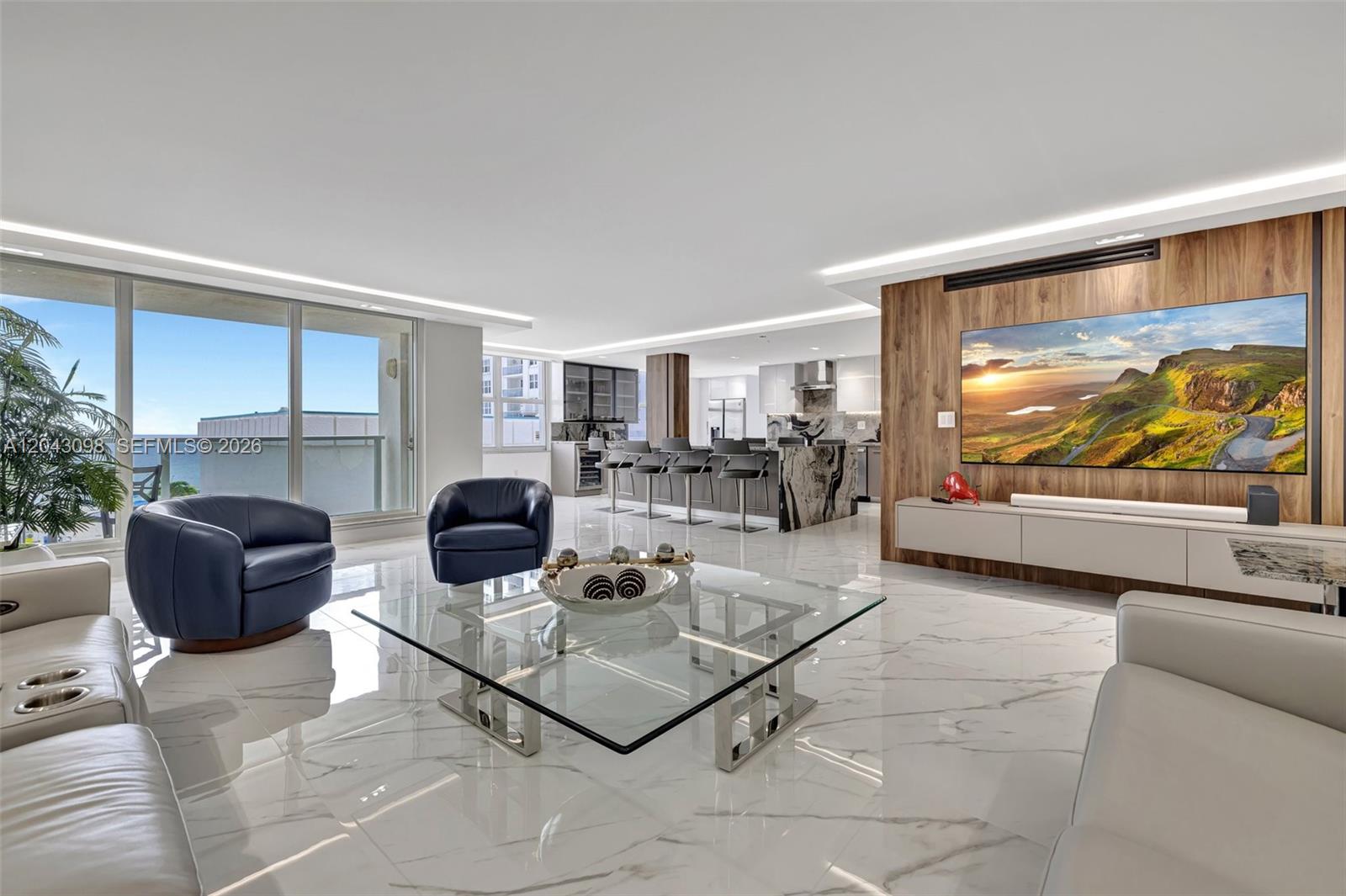 A modern open-concept living room features marble floors, a wood-paneled media wall, and ocean views — 2751 S Ocean Dr # 404N, Hollywood FL 33019, HOLLYWOOD, FL