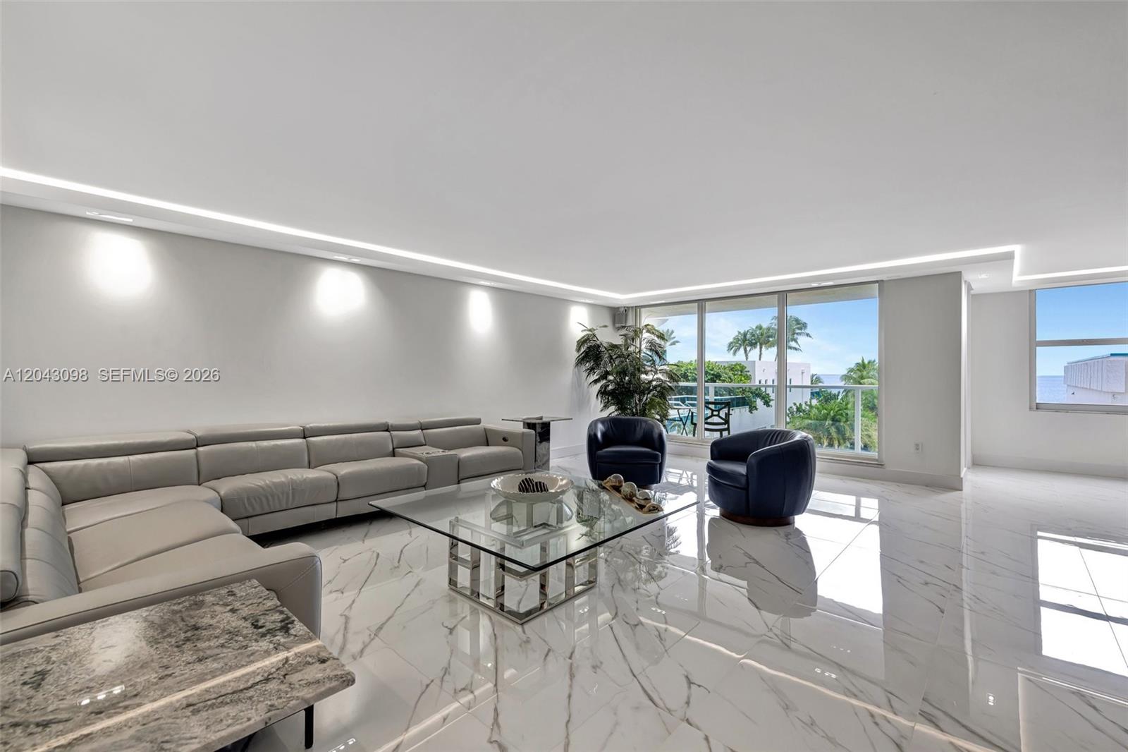 A modern living room features white marble floors, a grey sectional, and floor-to-ceiling windows — 2751 S Ocean Dr # 404N, Hollywood FL 33019, HOLLYWOOD, FL