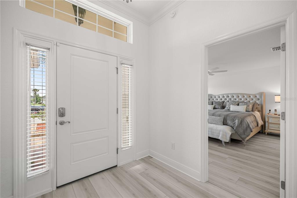A white front door with sidelights and a transom window opens into a foyer — 10367 ADDISON SHORE WAY, OXFORD, FL