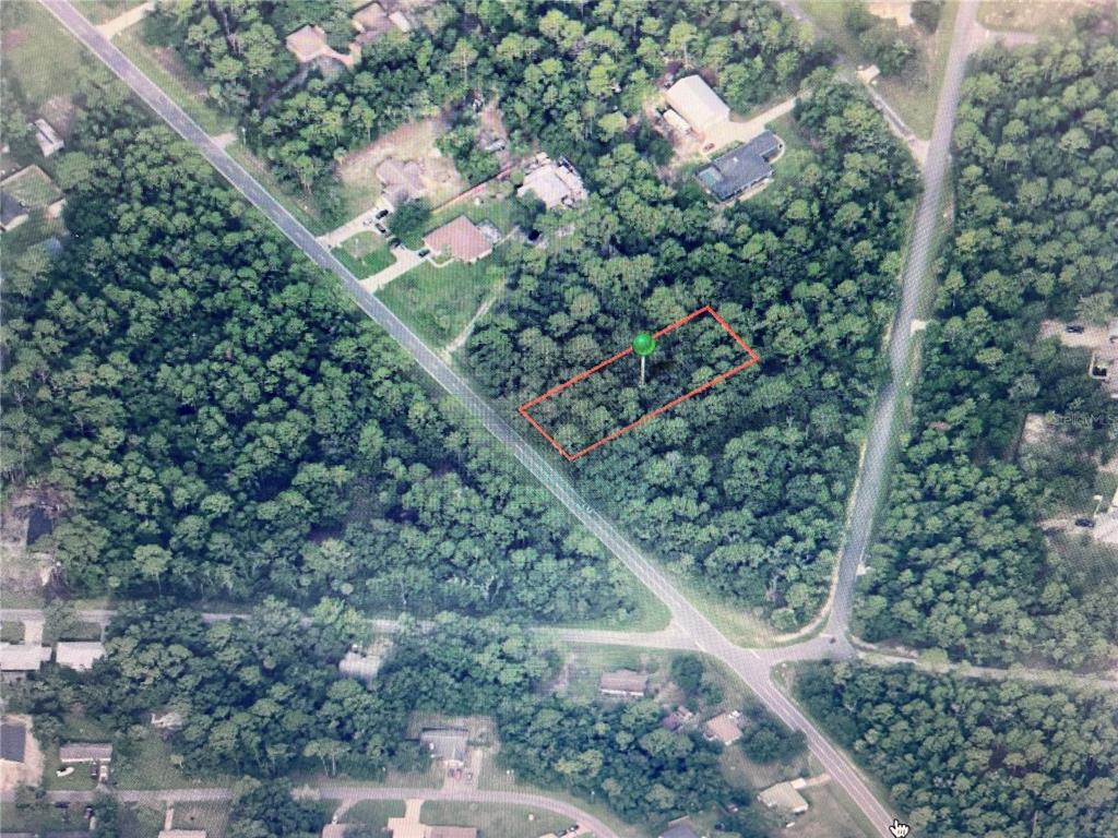 An aerial view shows a rectangular plot of land outlined in red amidst wooded surroundings — 10047 W DUNNELLON ROAD, CRYSTAL RIVER, FL
