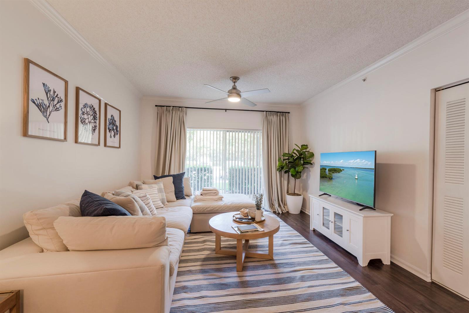 A living room features a sectional sofa, a round coffee table, and a television console — 3117 Tuscany Way, Boynton Beach FL 33435, BOYNTON BEACH, FL
