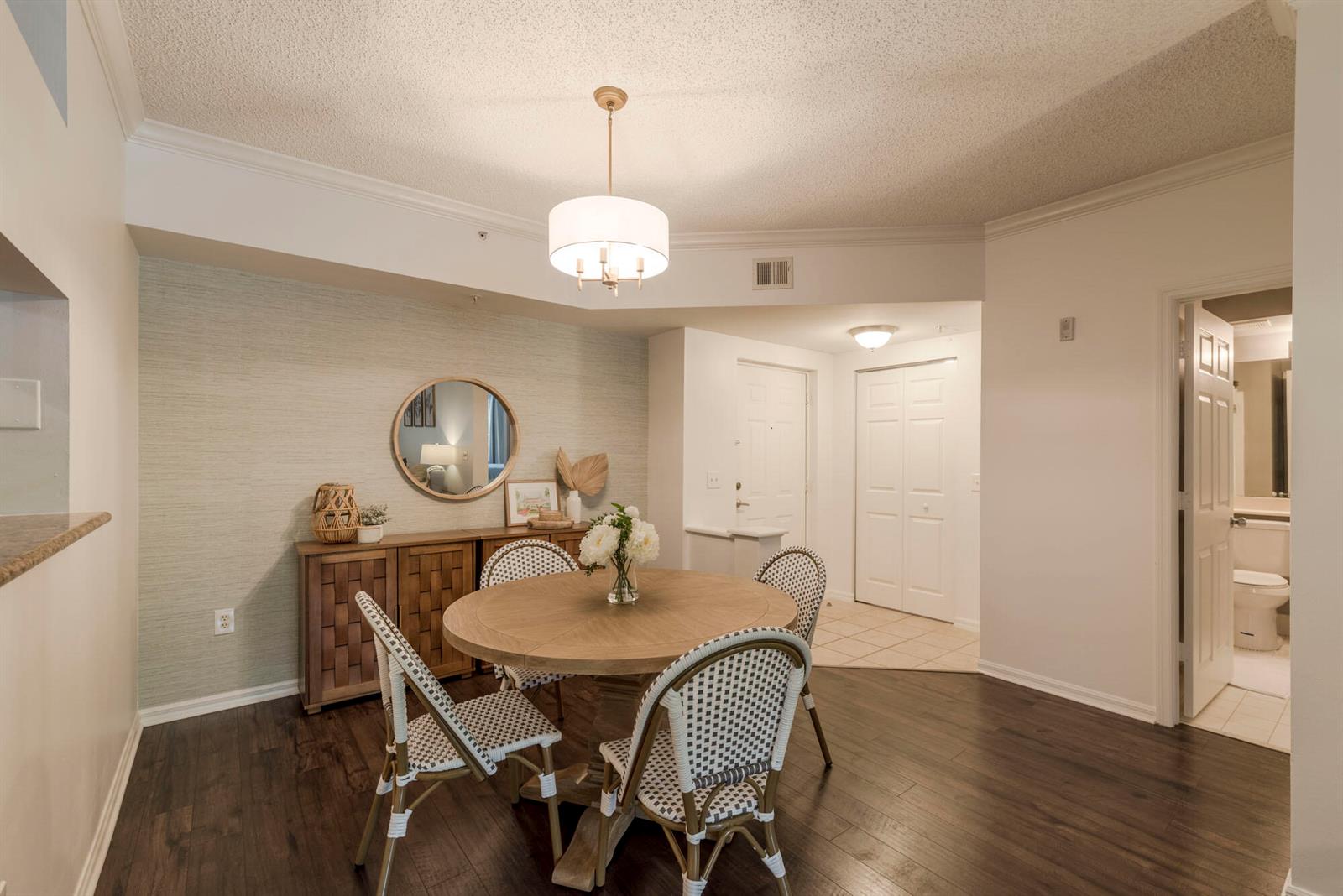 A dining room features a round wooden table, four woven chairs, and a sideboard — 3117 Tuscany Way, Boynton Beach FL 33435, BOYNTON BEACH, FL
