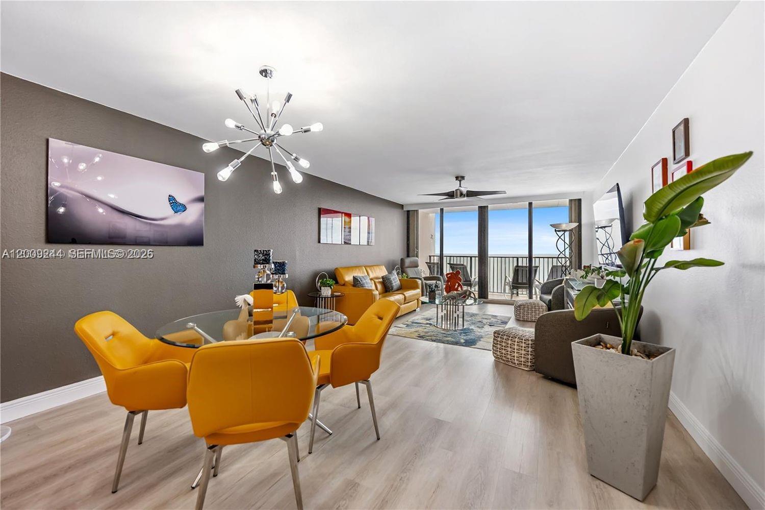 A living and dining area features yellow chairs, a glass table, and a balcony view — 2201 S Ocean Dr # 2202, Hollywood FL 33019, HOLLYWOOD, FL