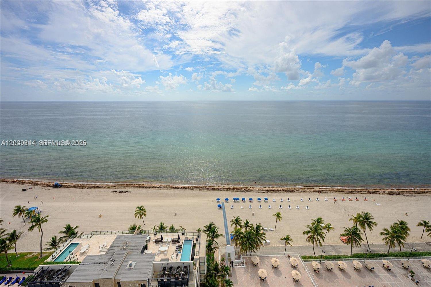 An elevated view of a sandy beach, ocean, and a building with a pool — 2201 S Ocean Dr # 2202, Hollywood FL 33019, HOLLYWOOD, FL