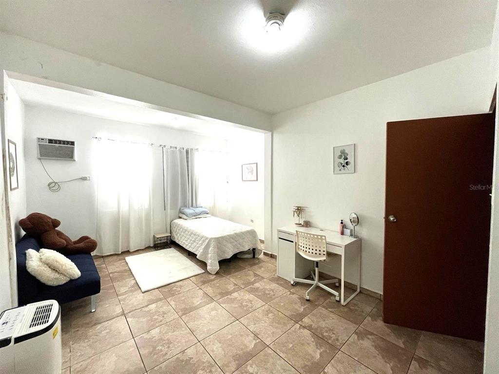 A bedroom features tile flooring, a twin bed, a desk, and a blue sofa — 62 CALLE BOGOTÁ, MAYAGUEZ, PR