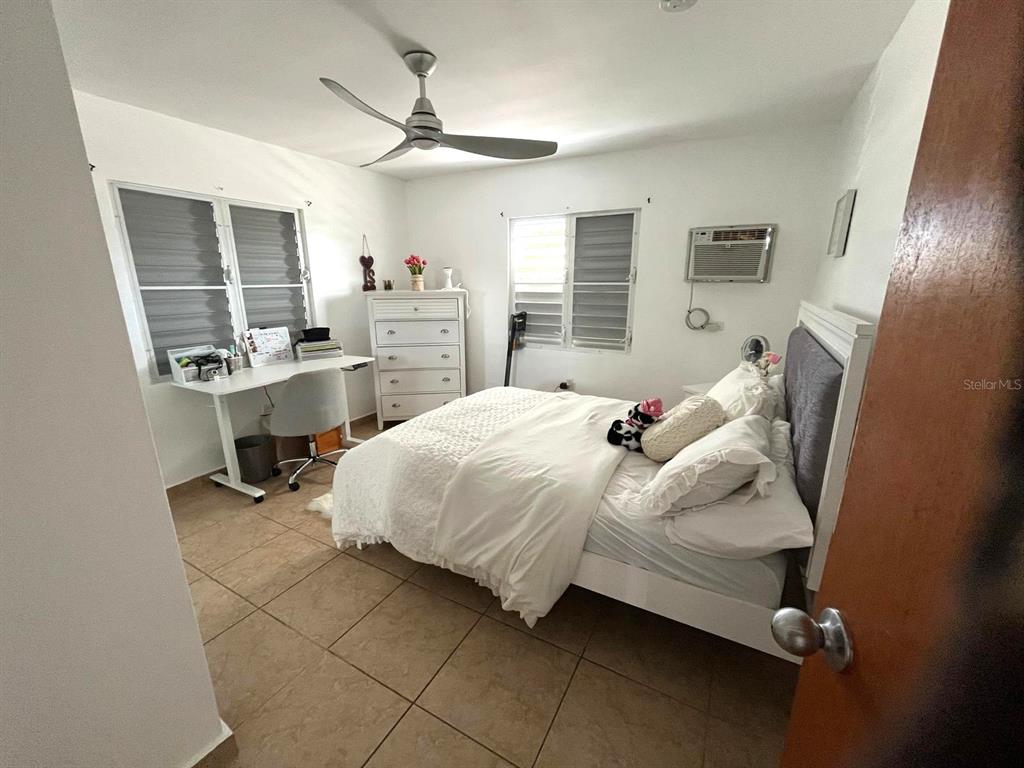 A bedroom features a bed, a desk, a dresser, tile flooring, and a ceiling fan — 62 CALLE BOGOTÁ, MAYAGUEZ, PR