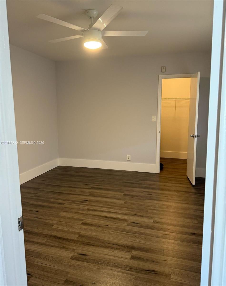 A bedroom features light gray walls, wood-look flooring, a ceiling fan, and an open closet — 1824 Monroe St # 14, Hollywood FL 33020, HOLLYWOOD, FL