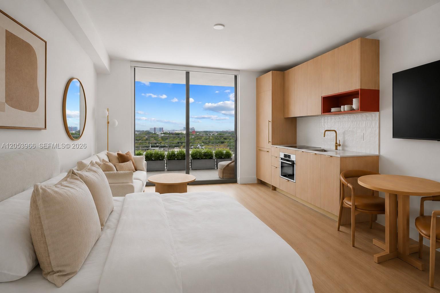 A studio apartment features a kitchenette, a bed, a dining area, and a balcony view — 90 NE 32nd St # 825, Miami FL 33127, MIAMI, FL