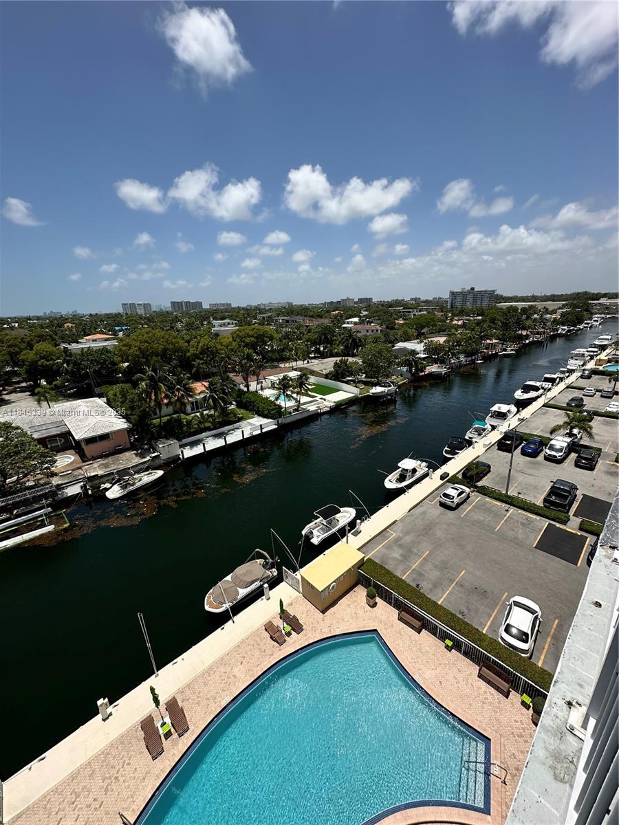 An elevated view of a swimming pool, a canal with docked boats, and a parking lot — 2020 NE 135th St # 807, North Miami FL 33181, NORTH MIAMI, FL