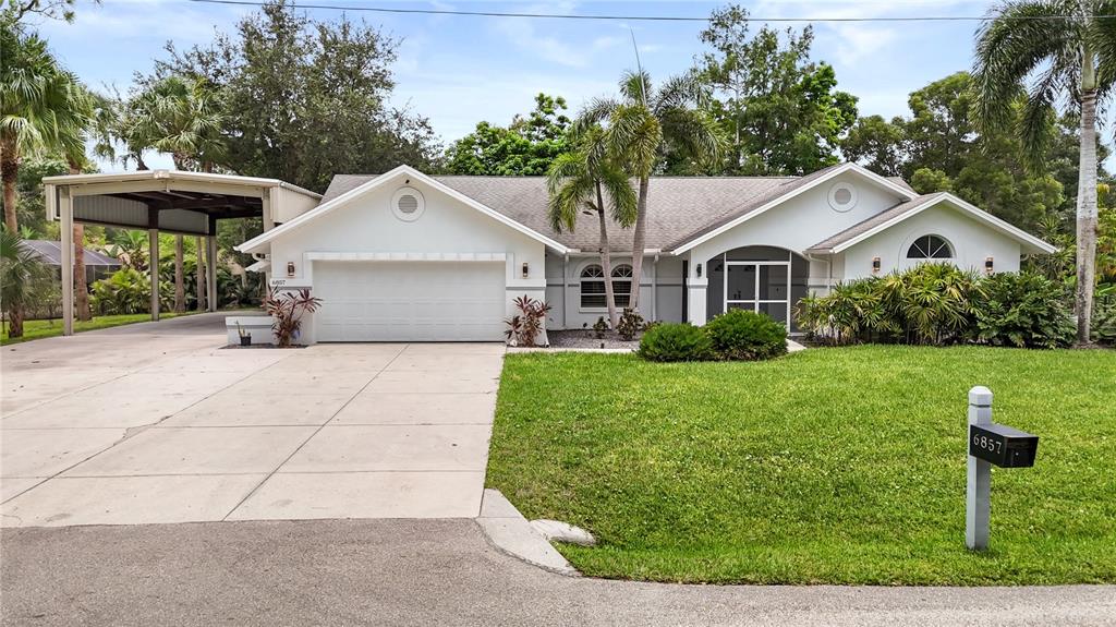 A single-story house with a white exterior, a two-car garage, and a detached carport — 6857 IDLEWILD STREET, FORT MYERS, FL