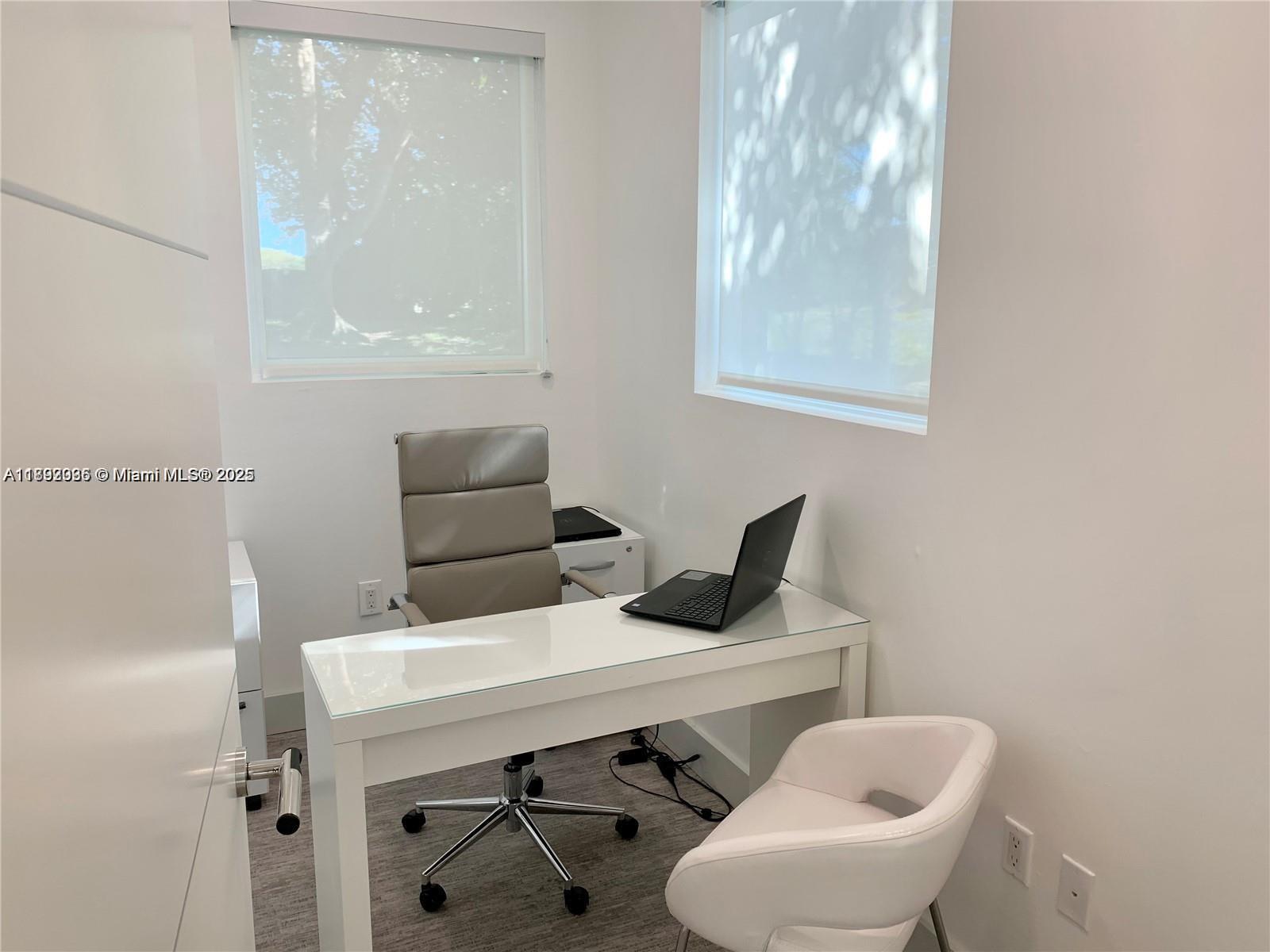 A small home office features a white desk, a gray chair, and two windows — 17100 Royal Palm Blvd # 1, Weston FL 33326, WESTON, FL