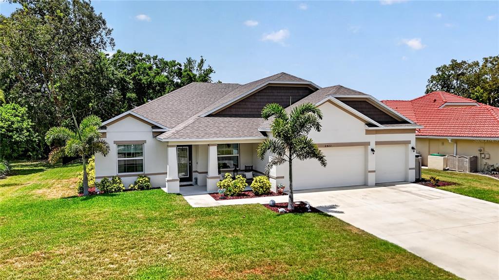 A kitchen and dining area with white cabinets, a granite island, and tile flooring — 2423 MALAYA COURT, PUNTA GORDA, FL