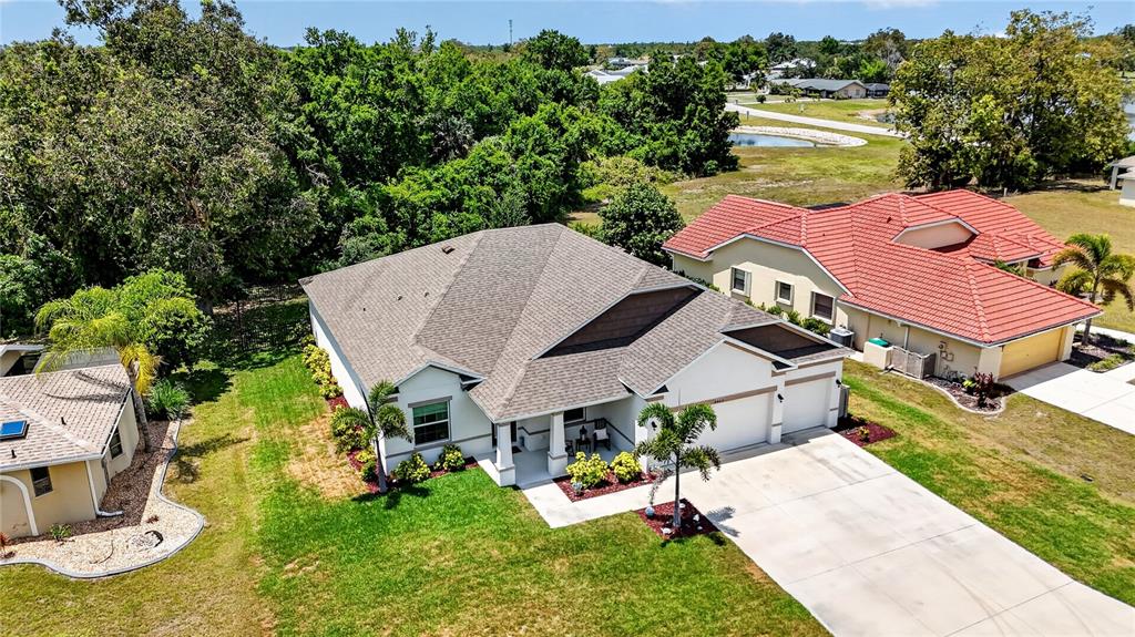 A screened-in patio features a dining set, a grill, and a view of the backyard — 2423 MALAYA COURT, PUNTA GORDA, FL