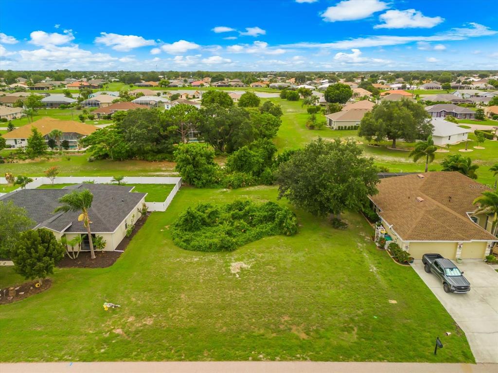 An aerial view shows a vacant residential lot situated between two single-family homes — 2381 MAURITANIA ROAD, PUNTA GORDA, FL