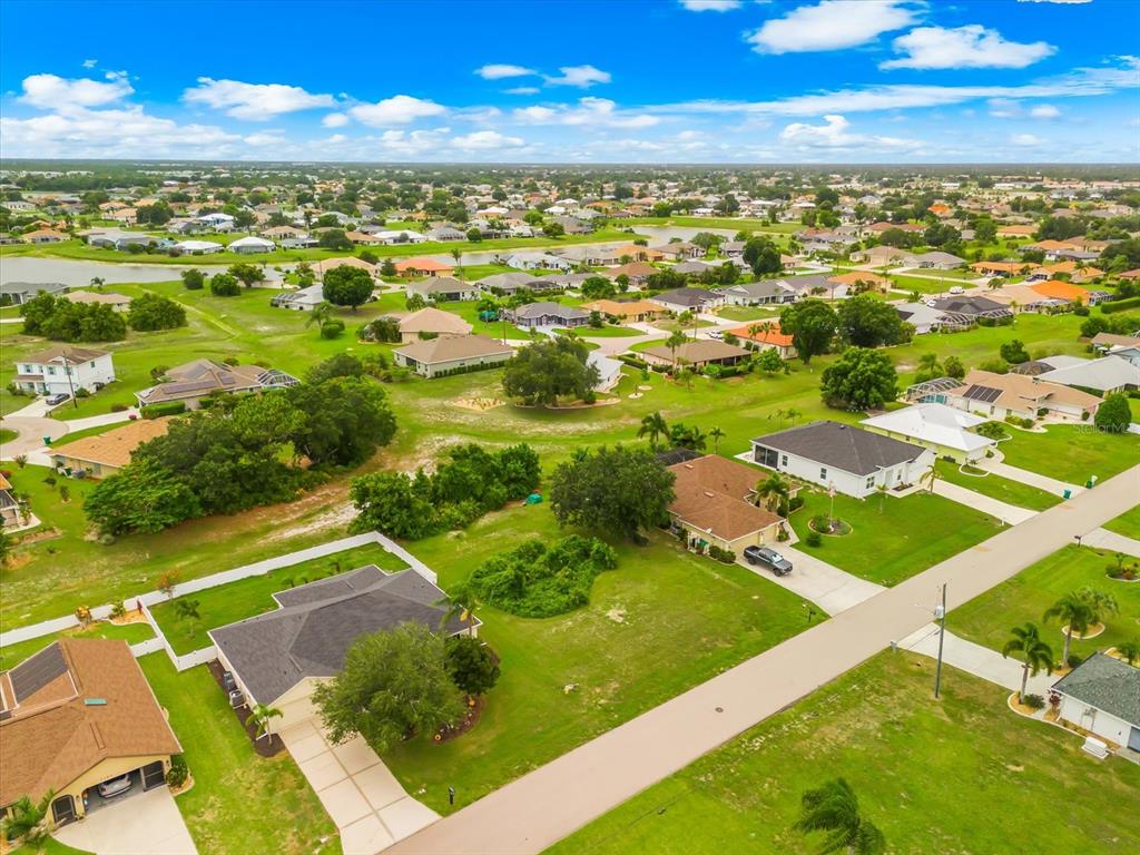 An aerial view of a residential neighborhood with single-family homes, green lawns, and paved streets — 2381 MAURITANIA ROAD, PUNTA GORDA, FL