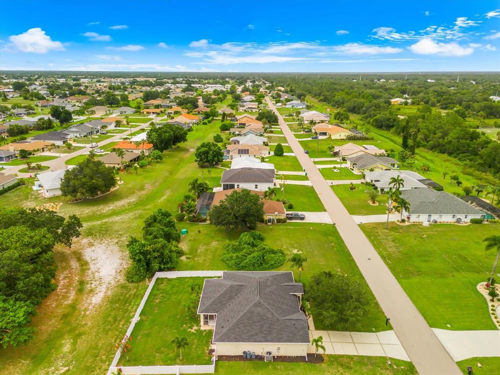 An aerial view shows a residential street lined with single-family homes and green lawns — 2381 MAURITANIA ROAD, PUNTA GORDA, FL