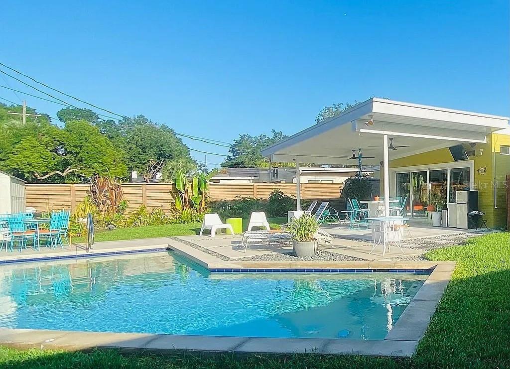 A covered patio with yellow brick walls, a ceiling fan, and an open doorway — 1402 CUMBIE STREET, ORLANDO, FL