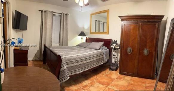 A bedroom features a bed, a large wooden wardrobe, a television, and tile flooring — 2306 Liberty St # C, Hollywood FL 33020, HOLLYWOOD, FL