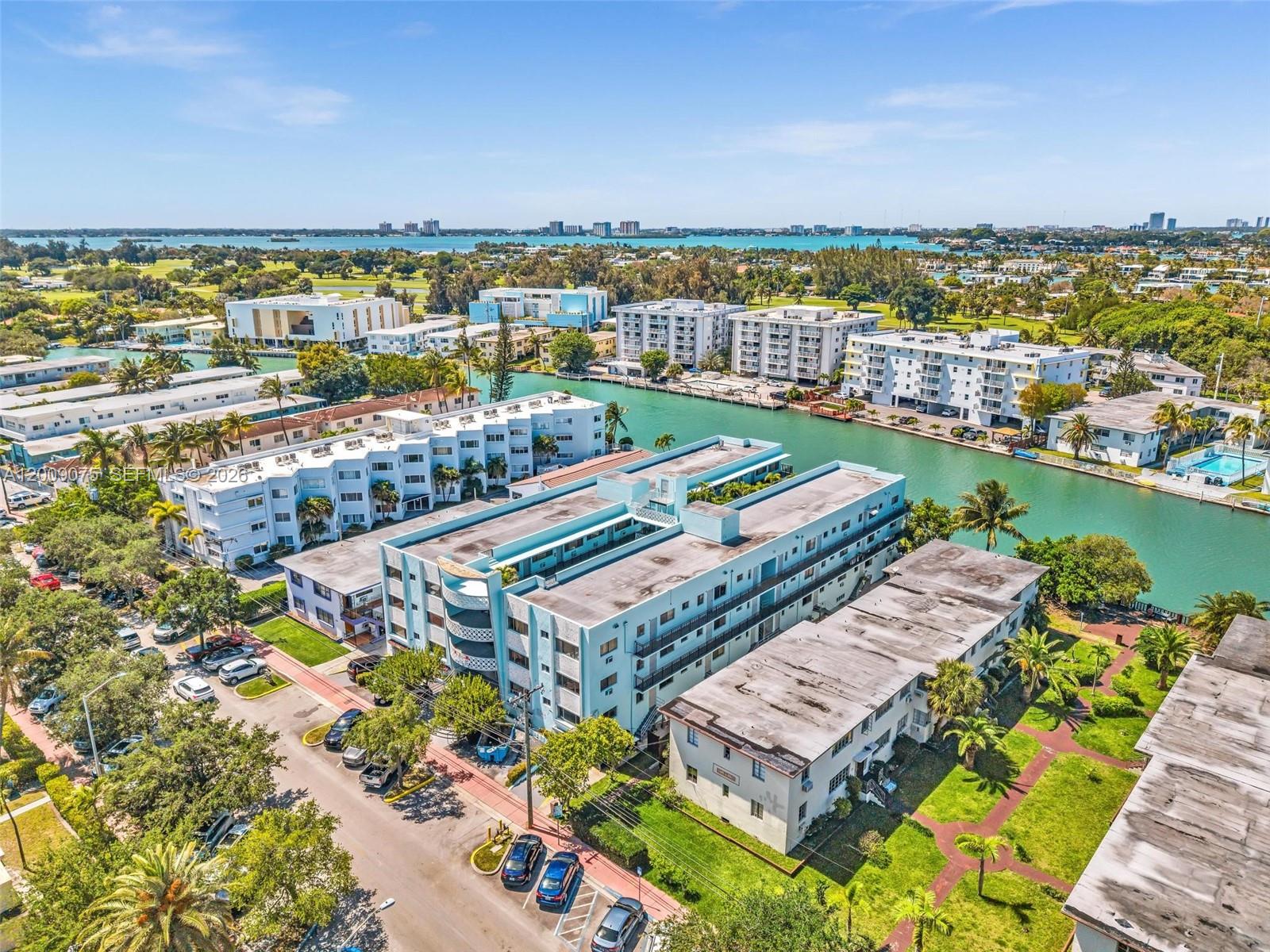 An aerial view of multi-story apartment buildings situated along a canal in a coastal area — 1165 Marseille Dr # 4, Miami Beach FL 33141, MIAMI BEACH, FL