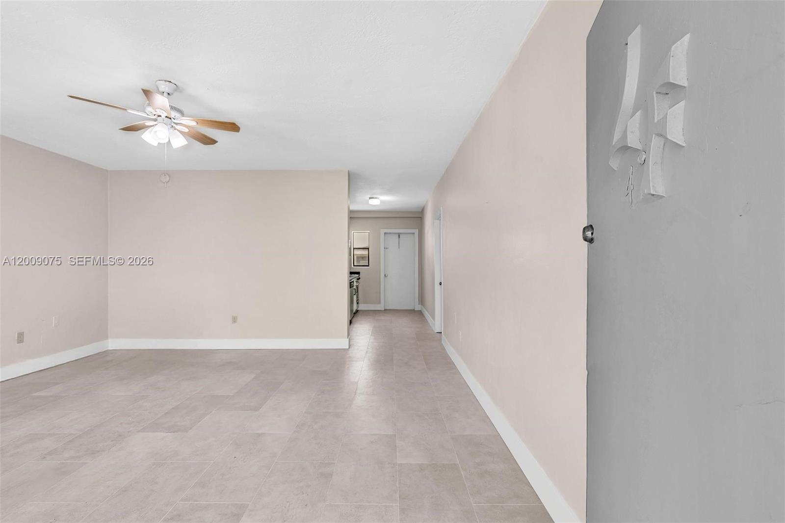 An empty room features light-colored walls, tile flooring, a ceiling fan, and a doorway — 1165 Marseille Dr # 4, Miami Beach FL 33141, MIAMI BEACH, FL