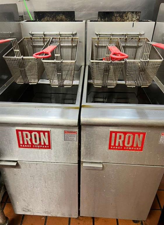 Two commercial deep fryers with wire baskets sit side-by-side in a kitchen setting — 3042 W SAND LAKE ROAD, ORLANDO, FL