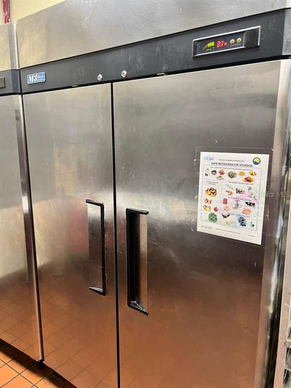 A stainless steel commercial refrigerator stands in a kitchen with tiled flooring — 3042 W SAND LAKE ROAD, ORLANDO, FL