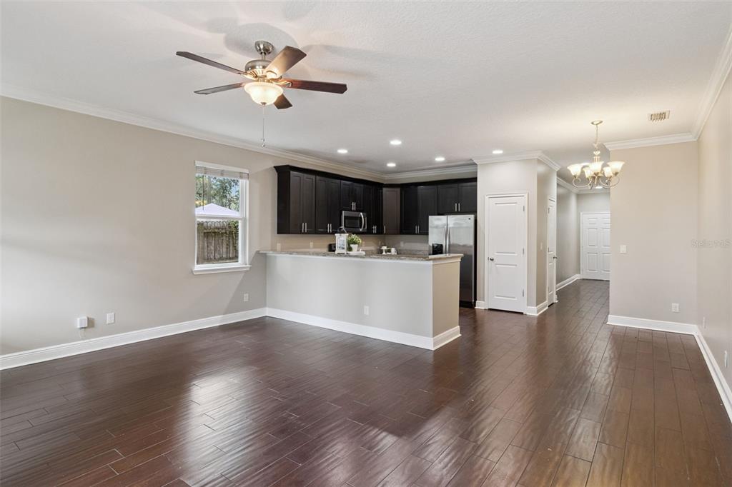 A kitchen features dark wood cabinets, granite countertops, stainless steel appliances, and a breakfast bar — 2544 MAYER STREET, ORLANDO, FL