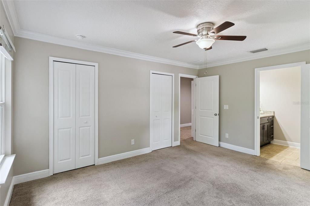 A backyard view of a two-story house with a covered patio and wooden privacy fence — 2544 MAYER STREET, ORLANDO, FL