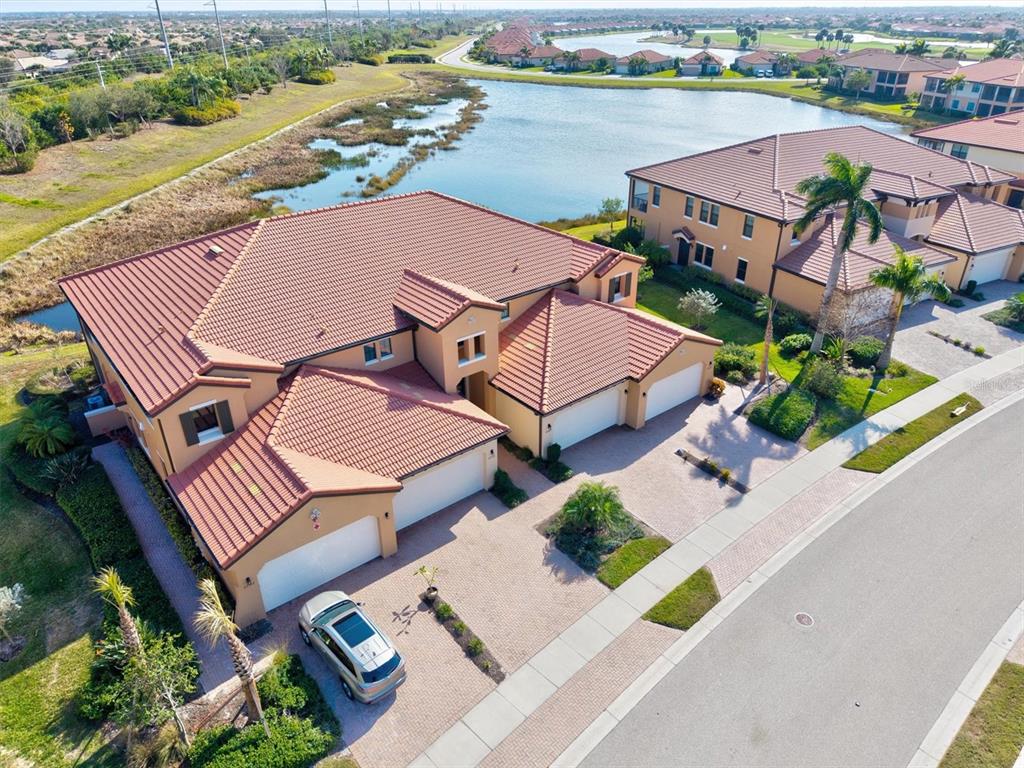 A kitchen features white cabinets, granite countertops, a center island with seating, and stainless appliances — 23516 AWABUKI DRIVE UNIT 201, VENICE, FL