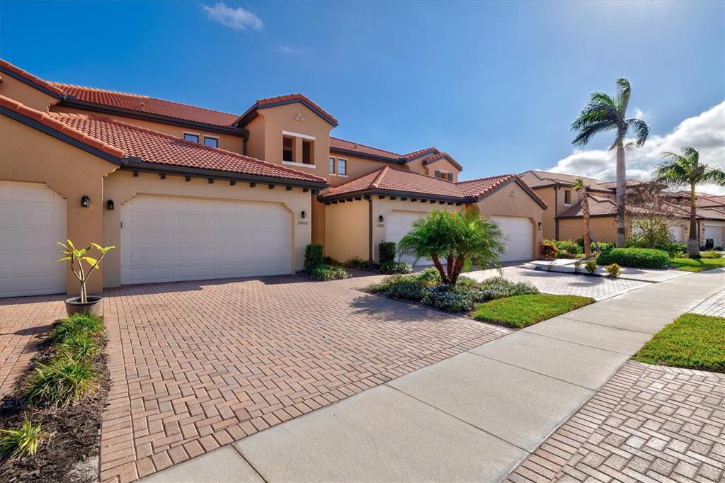 A kitchen features white cabinets, granite countertops, stainless steel appliances, and a large island — 23516 AWABUKI DRIVE UNIT 201, VENICE, FL