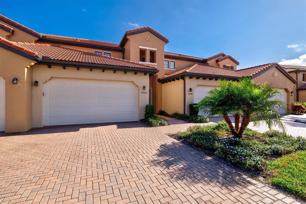 A view from a hallway into an open-concept living area with tile floors and balcony access — 23516 AWABUKI DRIVE UNIT 201, VENICE, FL