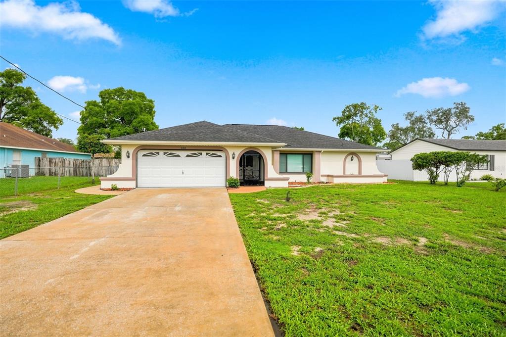 A single-story house with a white garage, arched entryway, and a concrete driveway — 10308 GIFFORD DRIVE, SPRING HILL, FL