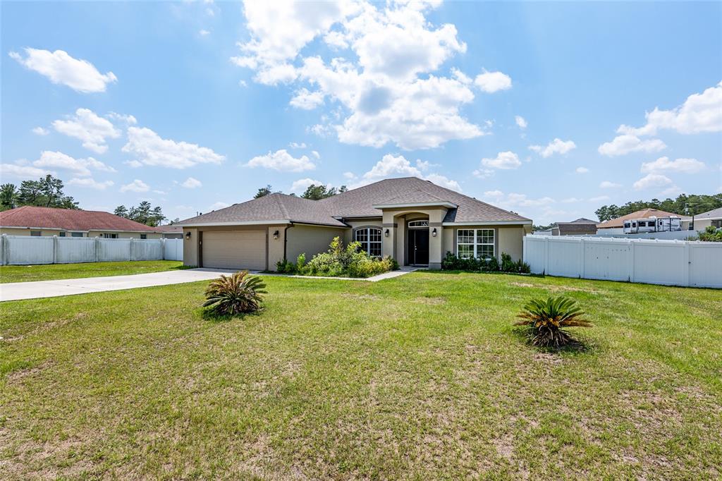 A black front door with sidelights and an arched transom window sits under a porch — 10910 SW 41ST AVENUE, OCALA, FL