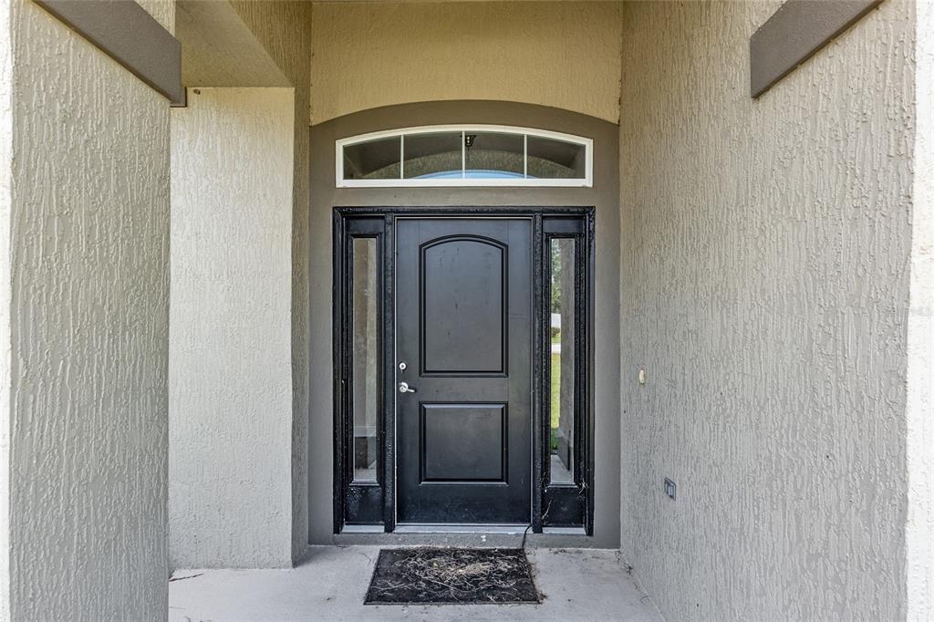 An open-concept kitchen and dining area features dark cabinetry, granite countertops, and wood-look tile flooring — 10910 SW 41ST AVENUE, OCALA, FL